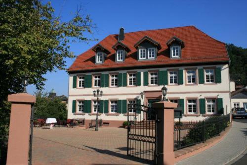 um grande edifício verde e branco com um telhado vermelho em Hotel Restaurant Ölmühle em Landstuhl