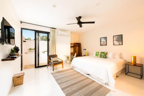 een witte slaapkamer met een bed en een plafondventilator bij Avela Boutique Hotel in Sayulita