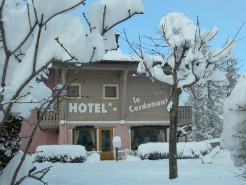 un hotel con árboles nevados delante de él en Le Cordonant, en Cordon