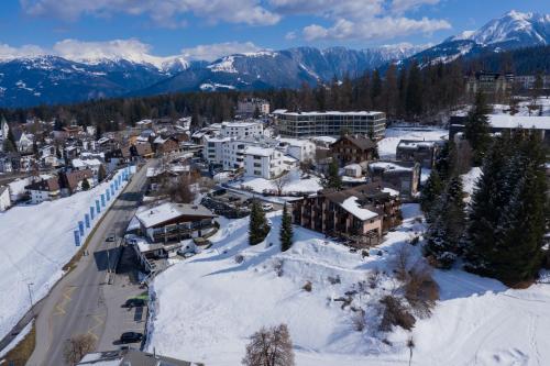 una vista aérea de una ciudad en la nieve en T3 Hotel Mira Val, en Flims