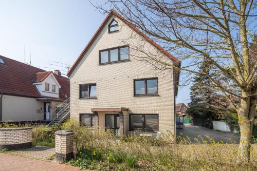 una casa in mattoni bianchi con finestre nere su una strada di Birkenhof a Norderney