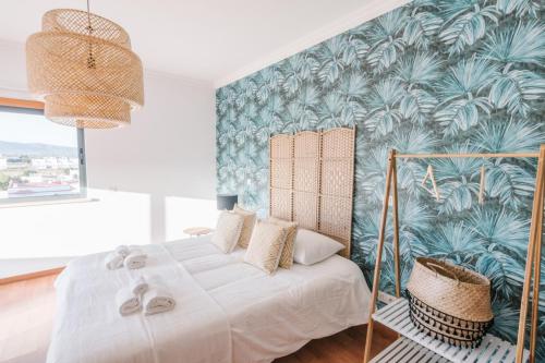 um quarto com uma cama grande e papel de parede tropical em Casas de Mar - Barra Mar em Olhão