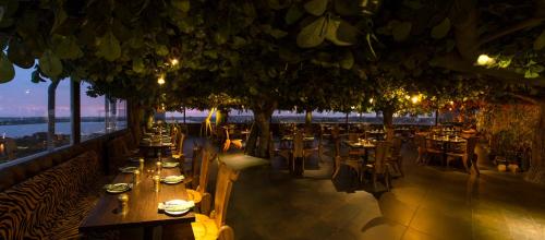 a restaurant with tables and chairs with a view at The President Hotel in Hubli