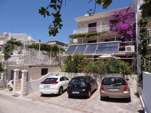 tres autos estacionados en un estacionamiento frente a un edificio en Balic Apartments - Hvar, en Hvar