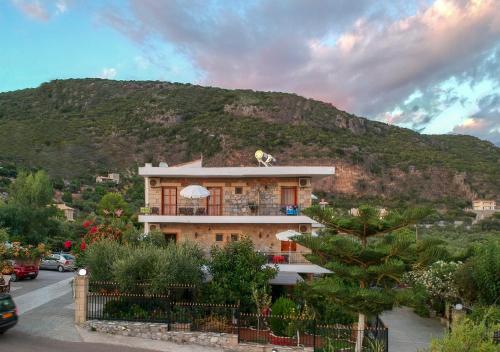 un edificio con una montaña en el fondo en Paradeisos, en Kardhamili