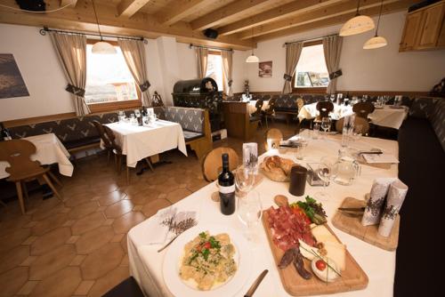 un restaurante con mesas con platos de comida. en Mahlknechthuette Seiseralm, en Alpe di Siusi