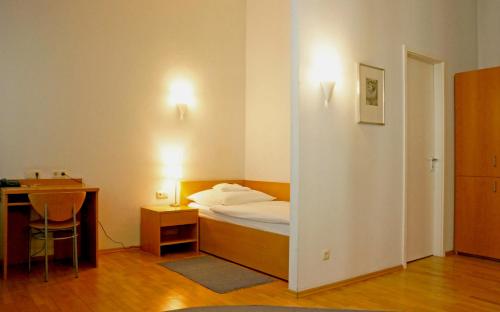 um quarto com uma cama, uma secretária e uma mesa em Hotel zum Scheppen Eck em Wiesbaden