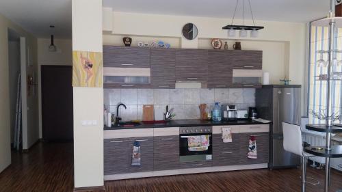 een keuken met houten kasten en een roestvrijstalen koelkast bij Apartment near Airport in Rīga