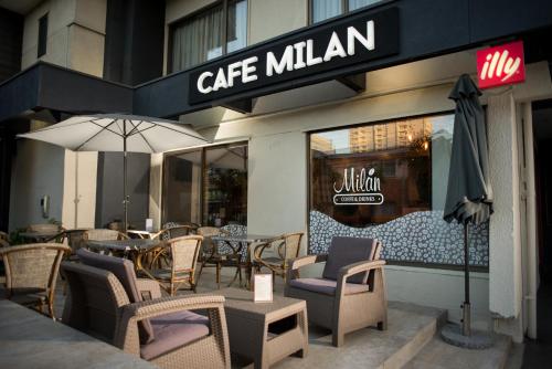 een cafe milan met stoelen en tafels en een paraplu bij Hostal La Cumbre in Temuco