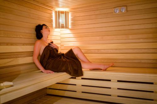 a woman is sitting in a sauna at Saint Georges Hotel & Spa in Chalon-sur-Saône