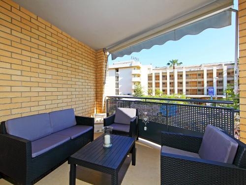 einen Balkon mit einem Sofa, einem Tisch und Stühlen in der Unterkunft Apartment Can Pavet by Interhome in Vilafortuny