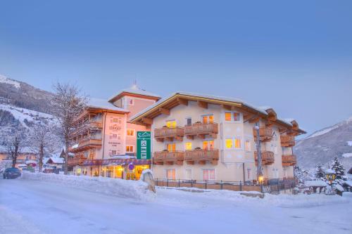 een gebouw op een met sneeuw bedekte straat voor de deur bij Hotel Steiger in Neukirchen am Großvenediger