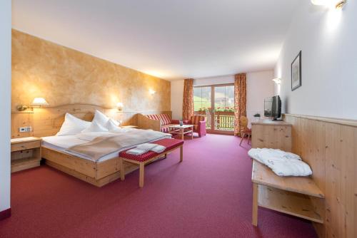 Hotel Torgglerhof في بريسانون: فندق غرفه بسرير وصاله