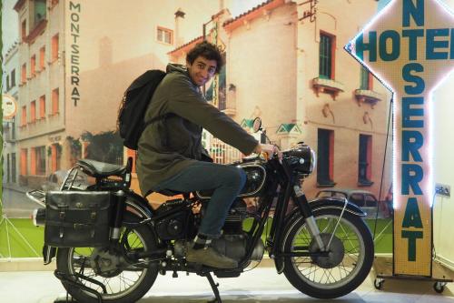 a man riding a motorcycle with a backpack at Hotel Montserrat in Sitges