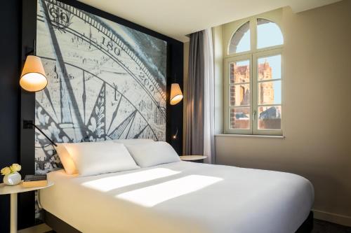 A bed or beds in a room at Mercure Beauvais Centre Cathédrale