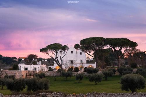 une maison blanche dans un champ arboré dans l'établissement Masseria Grofoleo, à Locorotondo