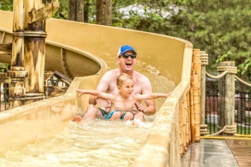 un homme et un enfant jouant sur un toboggan dans l'établissement Still Waters Resort, à Branson