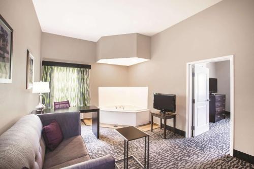 a living room with a couch and a television at La Quinta by Wyndham Baton Rouge Denham Springs in Baton Rouge