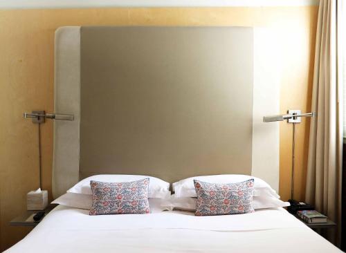 una camera con un letto bianco con due cuscini di Mill Street Inn a Newport