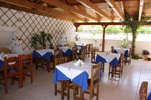 un restaurante con mesas y sillas con servilletas azules. en Hotel Galaxidi, en Galaxidhion