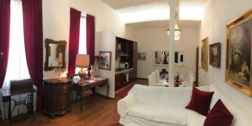 a living room with a white couch and a desk at Colosseo Room in Rome