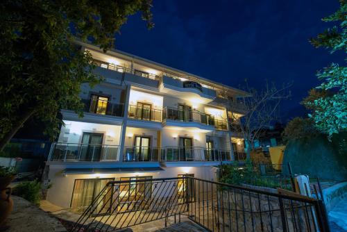 Un bâtiment blanc avec des lumières allumées la nuit dans l'établissement Seyir Beach Hotel, à Ölüdeniz