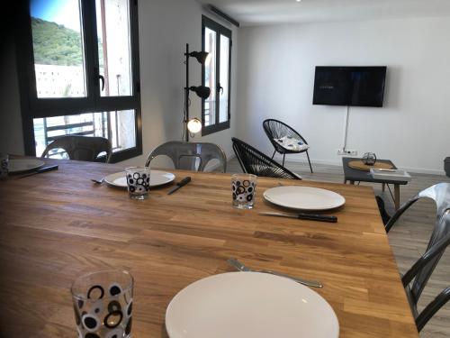 een eetkamer met een houten tafel en stoelen bij Appartement port bonifacio in Bonifacio