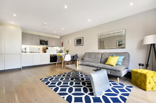 uma sala de estar com um sofá e uma cozinha em Esquire Apartments Ealing em Londres