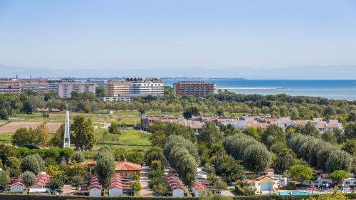 miasto z drzewami i budynkami i oceanem w obiekcie Olmi Lido Altanea w Caorle