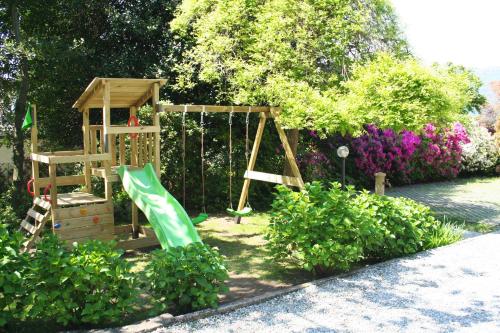 um parque infantil num jardim com um baloiço em Villa dei Fiori em Luino