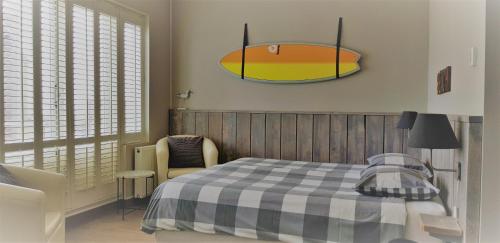 a bedroom with a bed and a surfboard on the wall at Zeehuis Zandvoort in Zandvoort