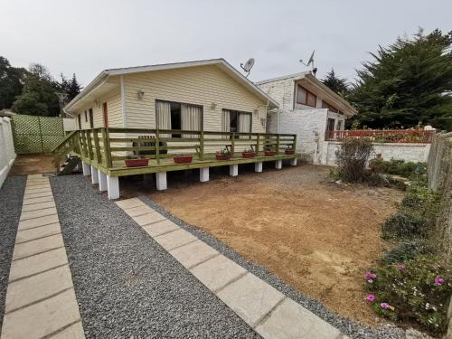 a house with a porch in a yard at Casas Isla Negra in El Quisco