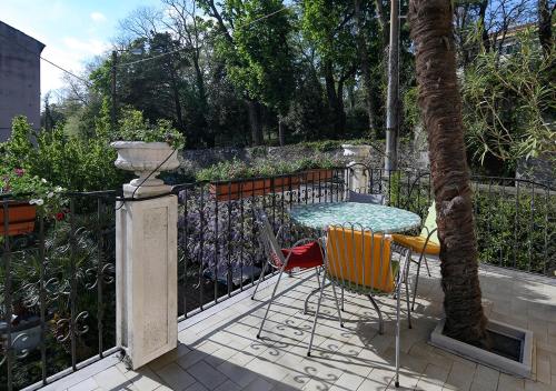 une terrasse avec une table et des chaises à côté d'une clôture dans l'établissement Le Palme Trieste, à Trieste