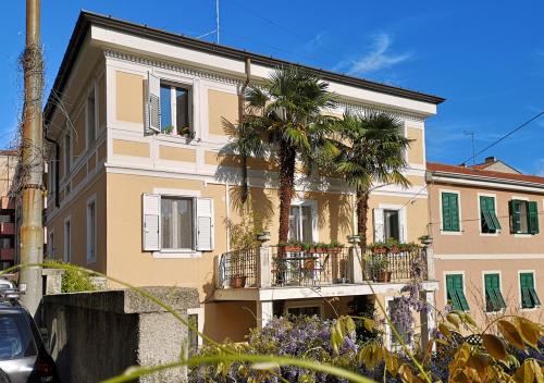 - un bâtiment avec des palmiers et un balcon dans l'établissement Le Palme Trieste, à Trieste