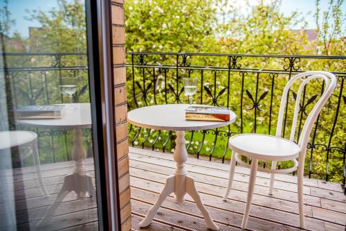 d'une table et de chaises sur un balcon avec une porte en verre. dans l'établissement Willa Laguna, à Kołobrzeg