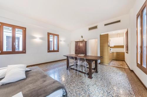 um quarto com uma mesa, uma cama e um frigorífico em Ca' d'Oro suite em Veneza