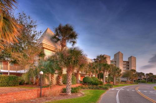 un edificio con palmeras frente a una calle en Oceanfront Litchfield Inn, en Pawleys Island