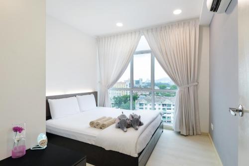 una camera con un letto e una grande finestra di Straits Garden Suites, Georgetown a George Town