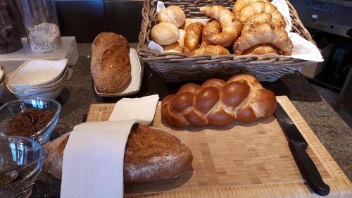 une table recouverte de beaucoup de différents types de pain dans l'établissement Ascott Hotel & Restaurant, à Rombach