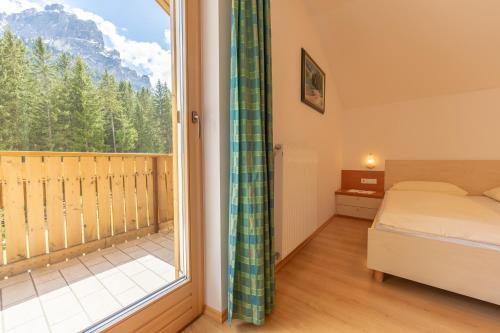 um quarto com uma cama e uma grande janela em Residence Trenker Luis em Braies