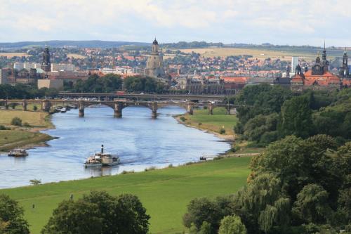 un pont sur une rivière avec une ville en arrière-plan dans l'établissement Hotel am Waldschlösschen - Brauhaus, à Dresde