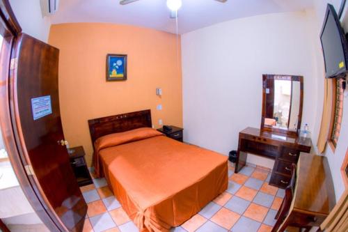 - une chambre avec un lit, une commode et un miroir dans l'établissement Hotel Los Girasoles, à Tepic