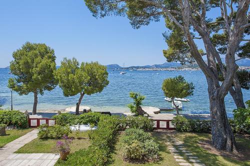 widok na plażę z drzewami i wodą w obiekcie Apartment Vora Dor w Port de Pollença