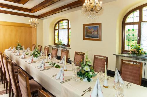 uma sala de conferências com uma mesa longa com flores em Hotel Stadt Löbau em Löbau