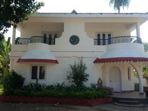 Cette maison blanche dispose d'un balcon. dans l'établissement Lifestyle villa, à Candolim