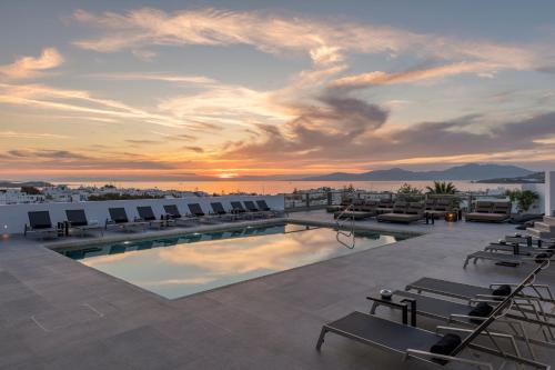 a pool on the roof of a building with chairs at Rochari Hotel in Mýkonos City