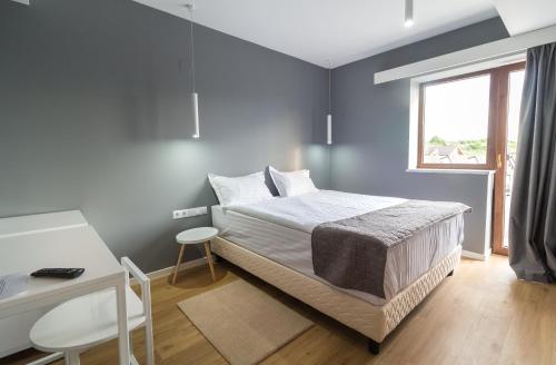 1 dormitorio con cama, escritorio y ventana en Horeum Boutique Hotel, en Sibiu