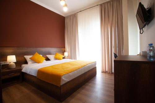 um quarto com uma cama e uma grande janela em Hotel Avenue 106 em Tbilisi