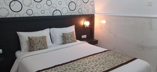 a bedroom with a large white bed with pillows at Asta House in Kuta