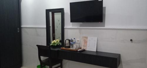 a bathroom with a black counter with a mirror at Asta House in Kuta